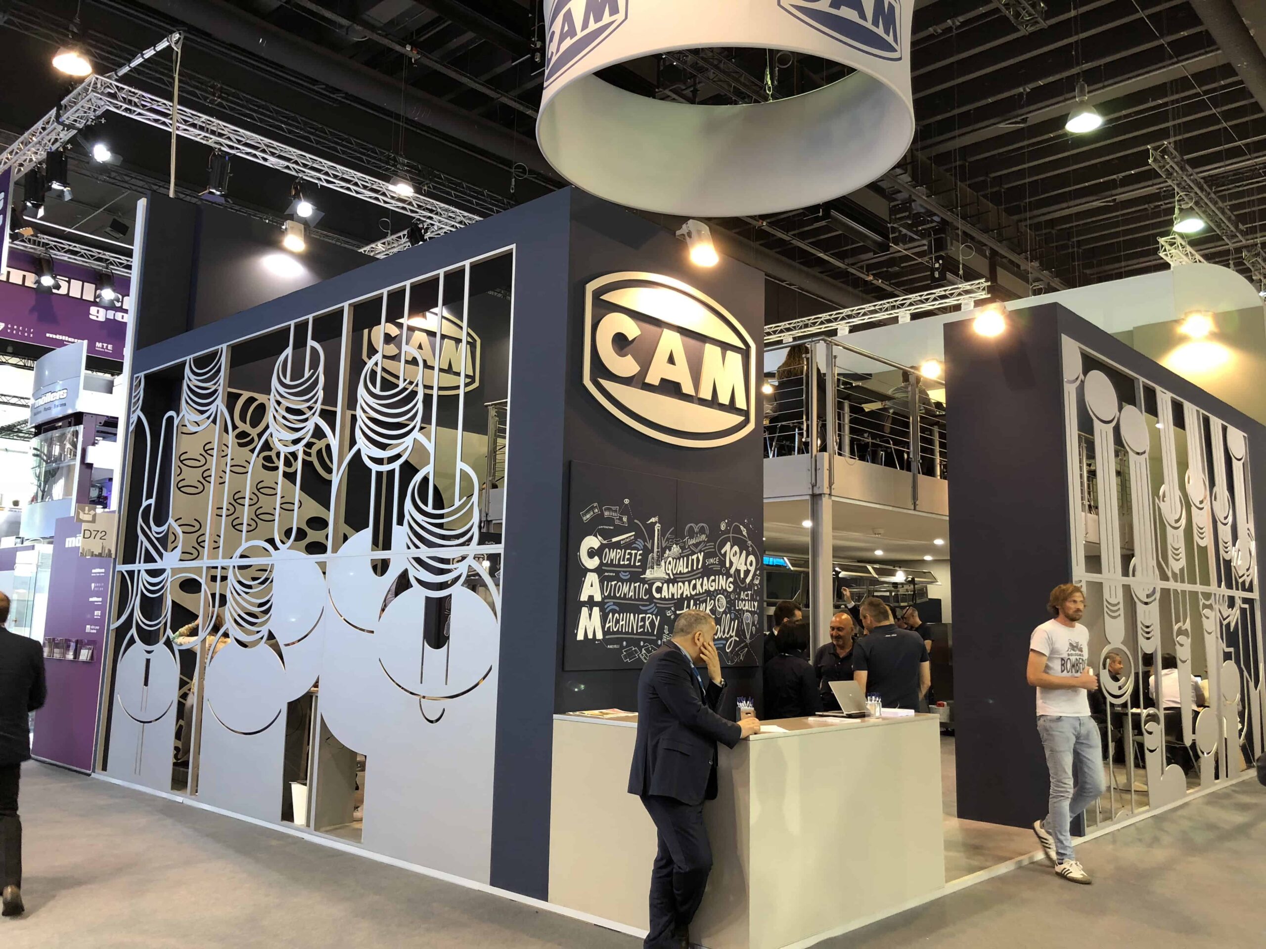 achema-2018-1 Stand CAM a Achema 2018 con logo aziendale e visitatori che interagiscono con lo staff, presentazione di macchine automatiche per il packaging.